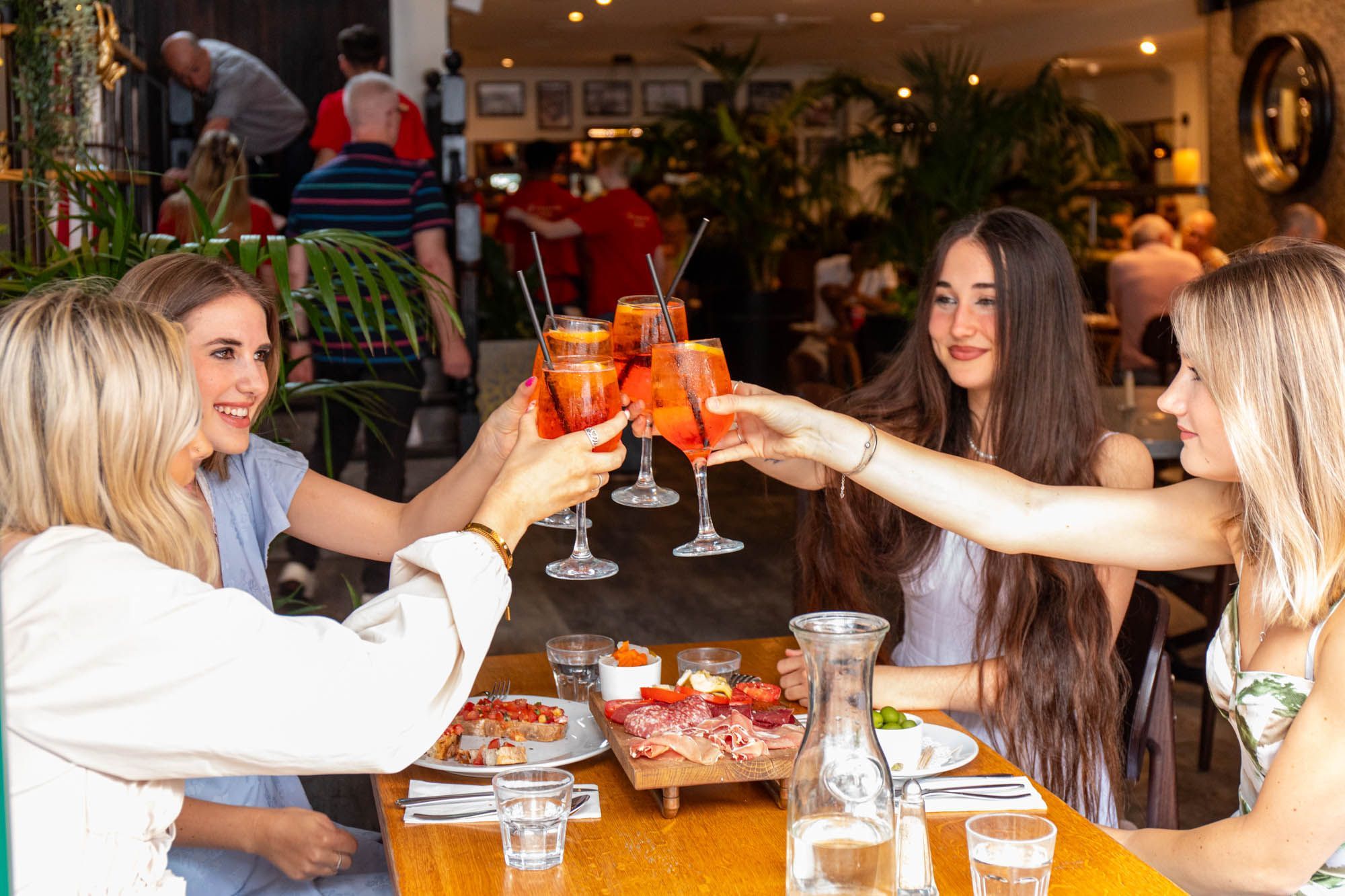 four girls having a toast with their drinks at Donatello Brighton