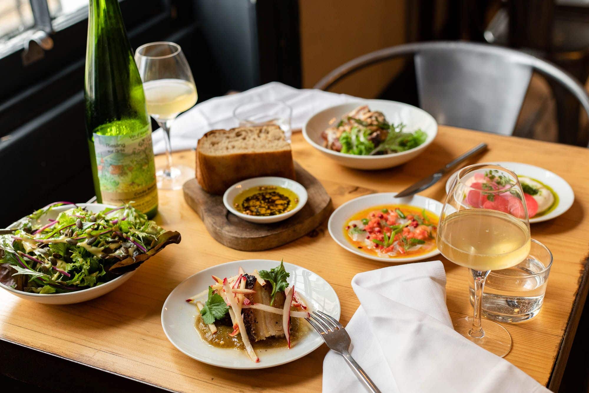 table laid out with the small plates and white wine