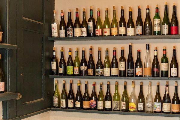 three shelves filled with wine bottles