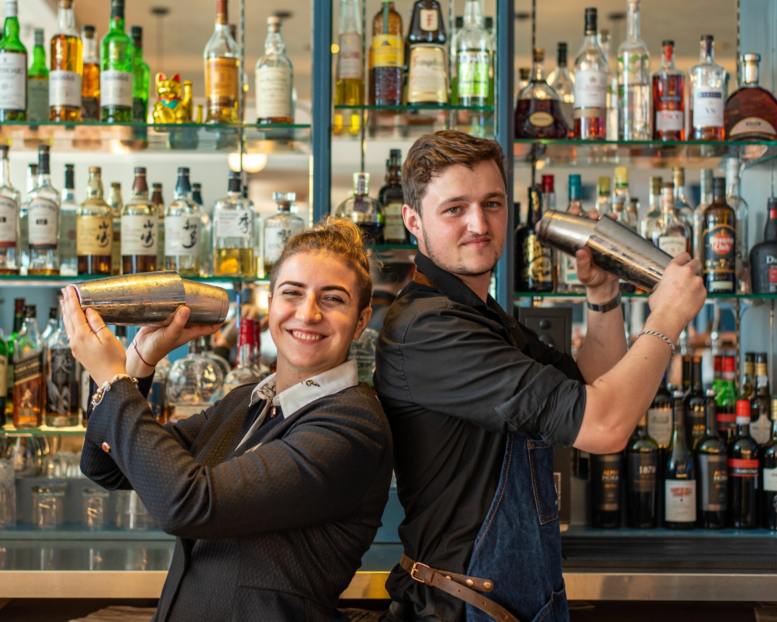 a guy and a girl bartenders mixing their cocktails at the Metropole bar