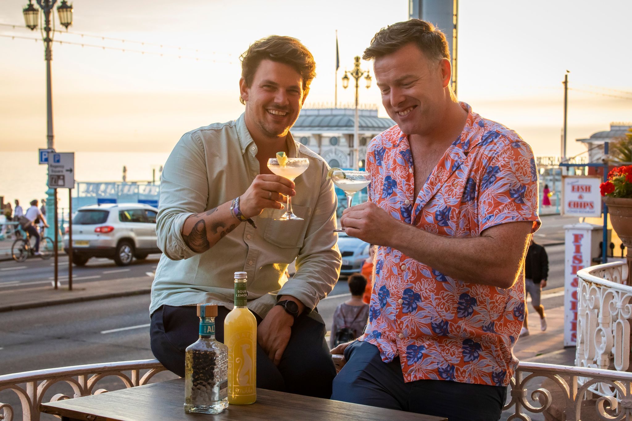 Brighton Metropole Bar terrace. Two men having a toast with their cocktails