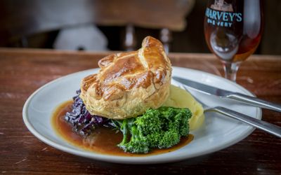 Pie, mash and gravy with greens, served with a glass of ale.