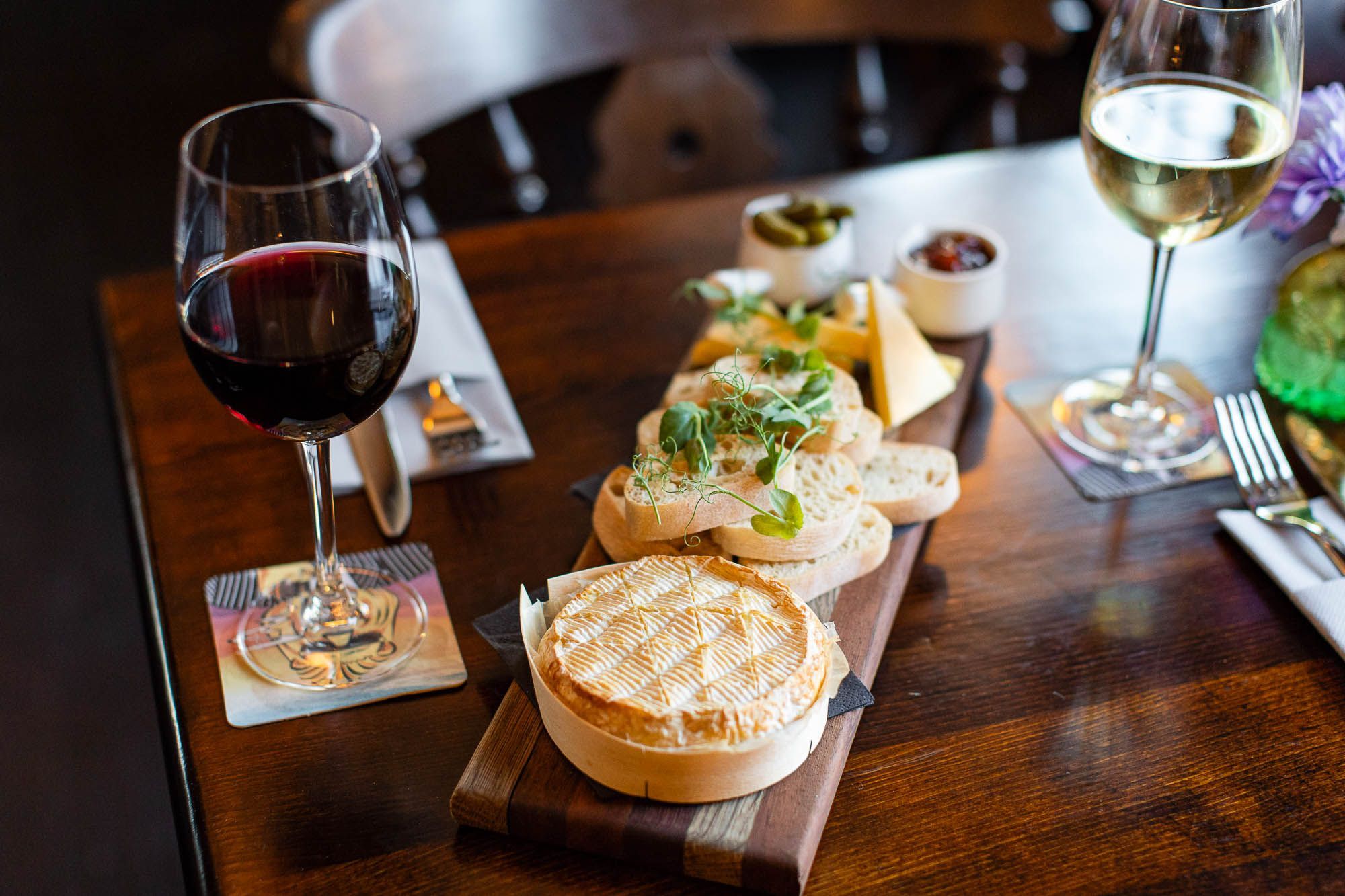 different types of cheese on the board served with glass of red wine