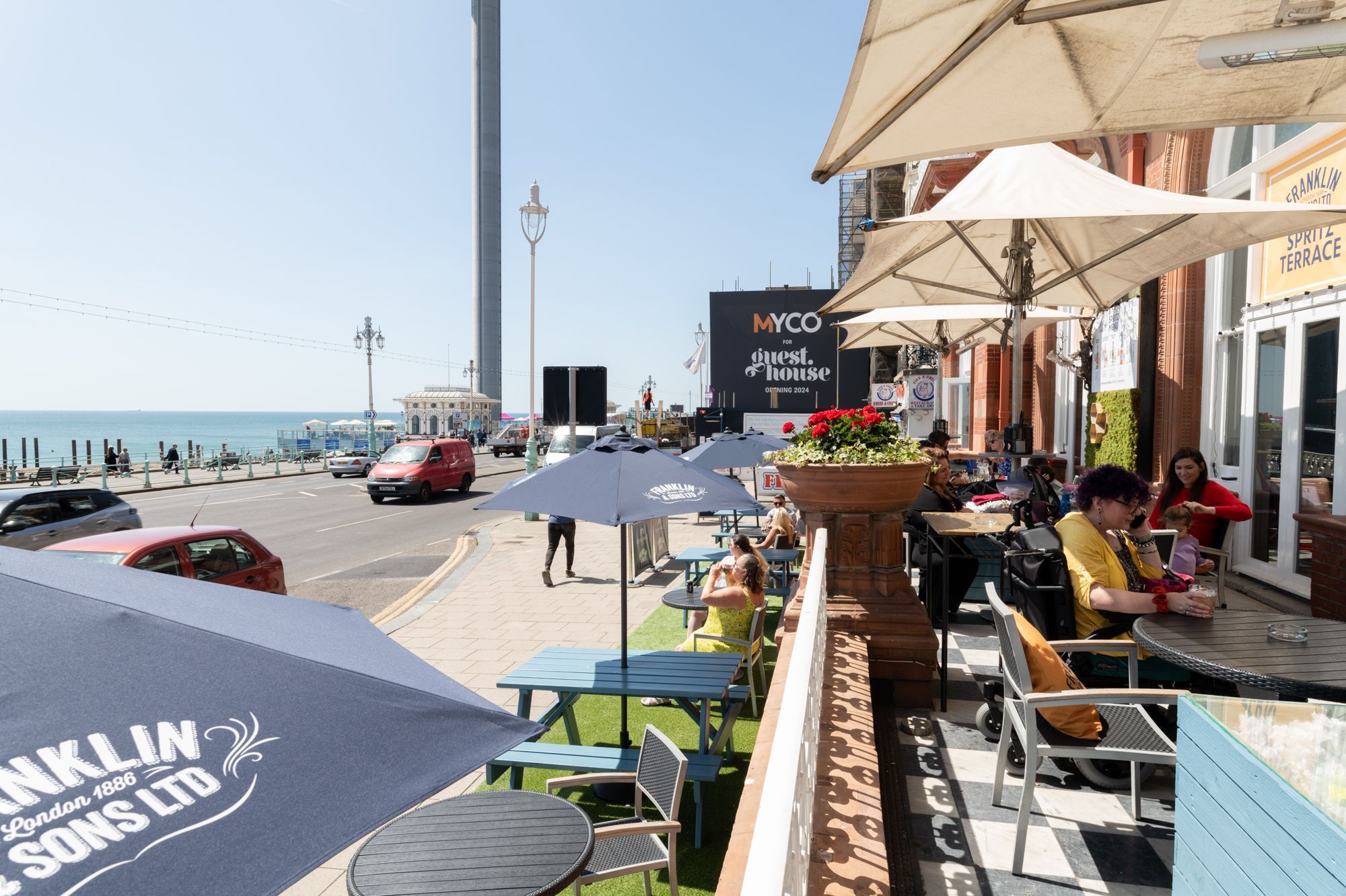 big terrace at the Metropole Bar, people sitting outside enjoying sun and drinks