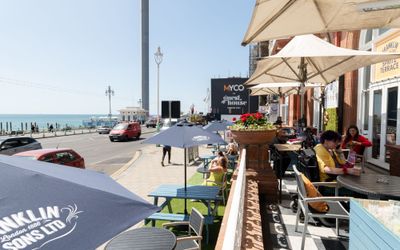 big terrace at the Metropole Bar, people sitting outside enjoying sun and drinks