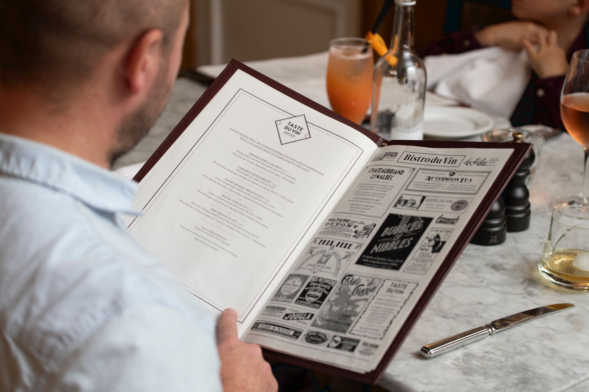 a man reading Hotel Du Vin menu