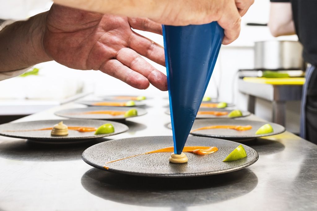 Close up of a piping bag finishing of a small plate