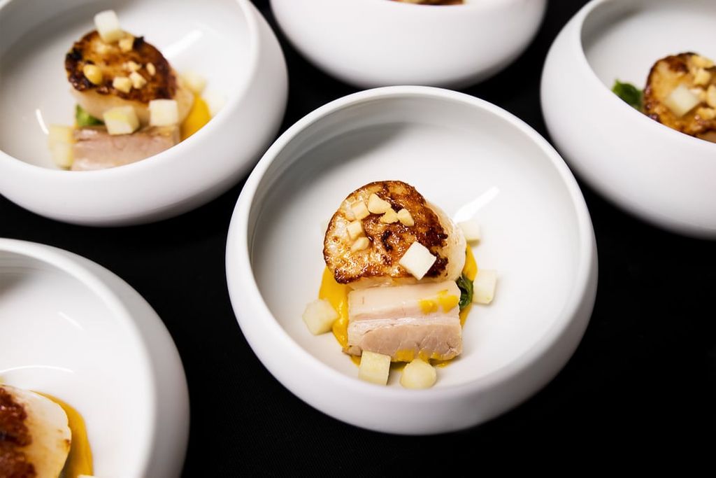 Rows of white bowls containing one of the courses at The Little Fish market