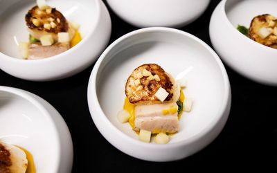 Rows of white bowls containing one of the courses at The Little Fish market