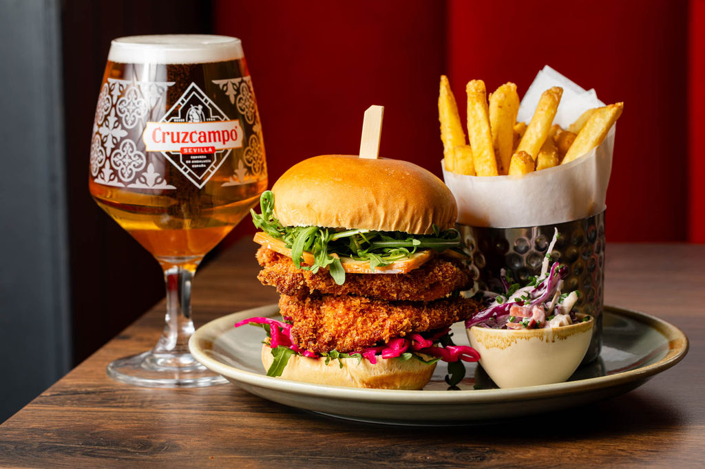 delicious looking burger with double fried meat patty and salad, served with glass of beer and fries
