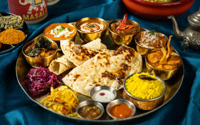 a thali dish at Indian Summer in Brighton, southern indian food, presented on railway thali tray. Vibrant colours