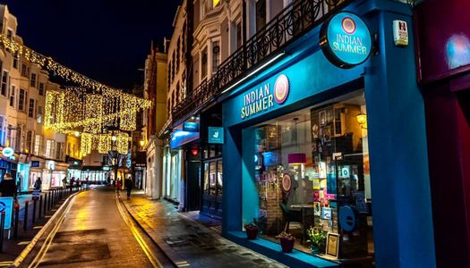 the blue facade of Indian Summer with twinkly lights in the background.
