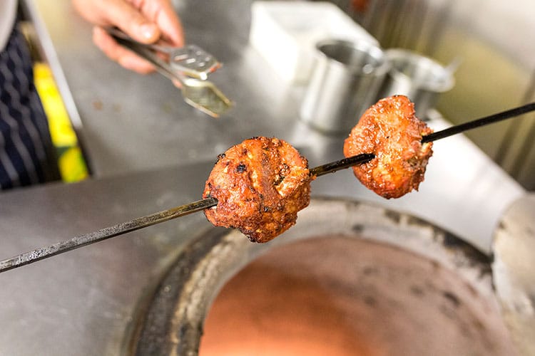 Meat on skewer in the kitchen at Indian restaurant, Chaula's Lewes