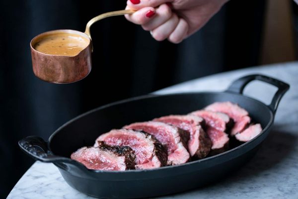 filet steak in black bowl with mushroom sauce on the side