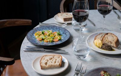 Fish Brighton Restaurant, seafood restaurant Brighton. The Coal shed expertly cooks fish on their josper oven. Pictured is a plate of salmon on a white plate on a marble table top.