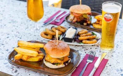 two boards with sliders and chips, served with some onion rings, sauce and glasses of beer, Lunch in Brighton. Gastro Pubs Brighton