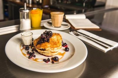 Stack of pancakes with blueberries and maple syrup