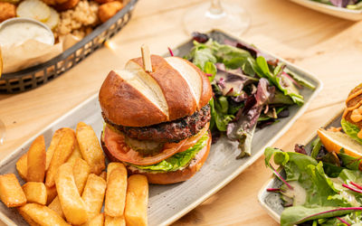 burger and chips served with some veggies on the grey plate