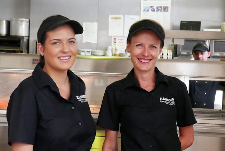 the team working behind the counter at bankers wearing a black uniform. 2 ladies. 