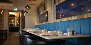 dining room at The Salt Room, Brighton seafront restaurants. Pictured blue banquet seating against a backdrop of wooden walls.