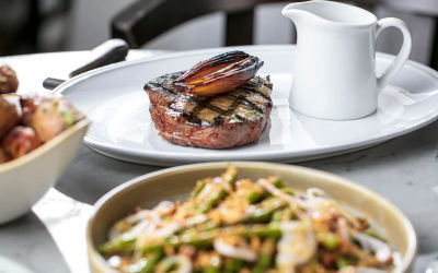 The Salt room, white plate with the peace of steak. While renowned for its seafood, The Salt Room also excels in premium steak dishes. Expect expertly grilled 28-day dry-aged ribeye or sirloin, served with sides like beef dripping chips or seasonal greens.