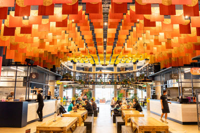 Inside Shelter Hall, rows of benches beneath an orange ceiling and food counters on either side
