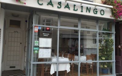 Exterior shot of Casalingo restaurant. Restaurant exterior shot of Casalingo entrance and large window with hanging baskets. Italian restaurant in Brighton. Preston Street Brighton