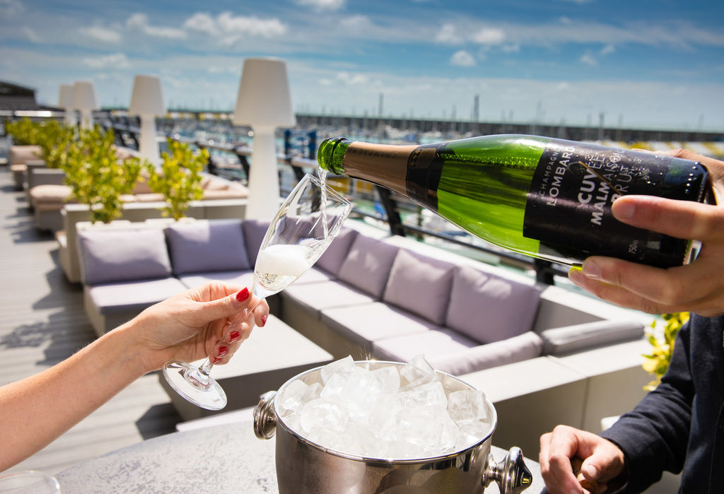 person sipping champagne on the terrace of the Malmaison hotel. Boutique Hotels Brighton. Brighton marina restaurants with views over the sea and the harbour. Boutique Hotels Brighton. Romantic restaurants in Brighton. Brighton seafront restaurants. Part of our Sussex restaurants guide