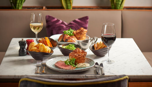 table at Malmaison Brighton laid out for two, Sunday roast served with glass of red and white wine