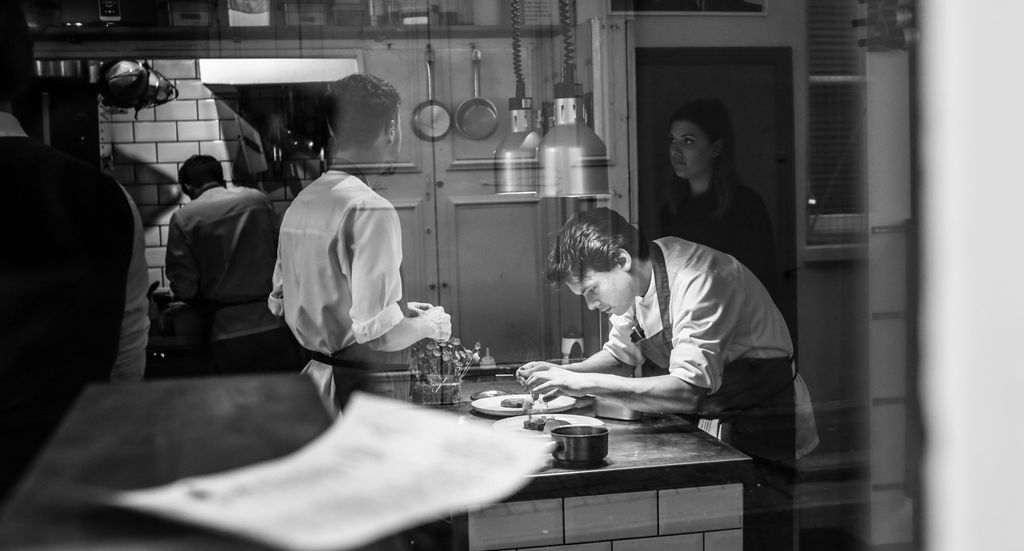 George at Isaac At restaurant. a picture where the camera is looking in through the window. Black and white photo. 