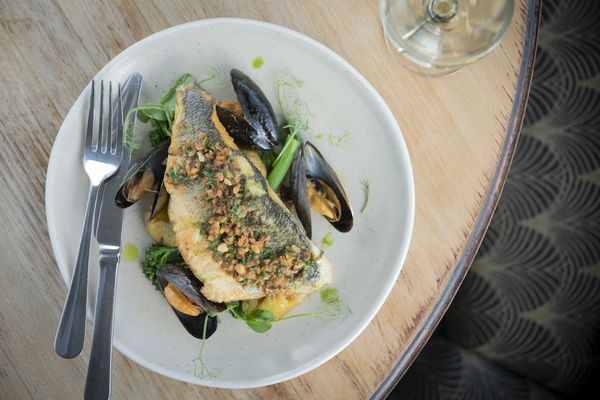 A plate of white fish with large mussels and a savoury crumb to top the fish