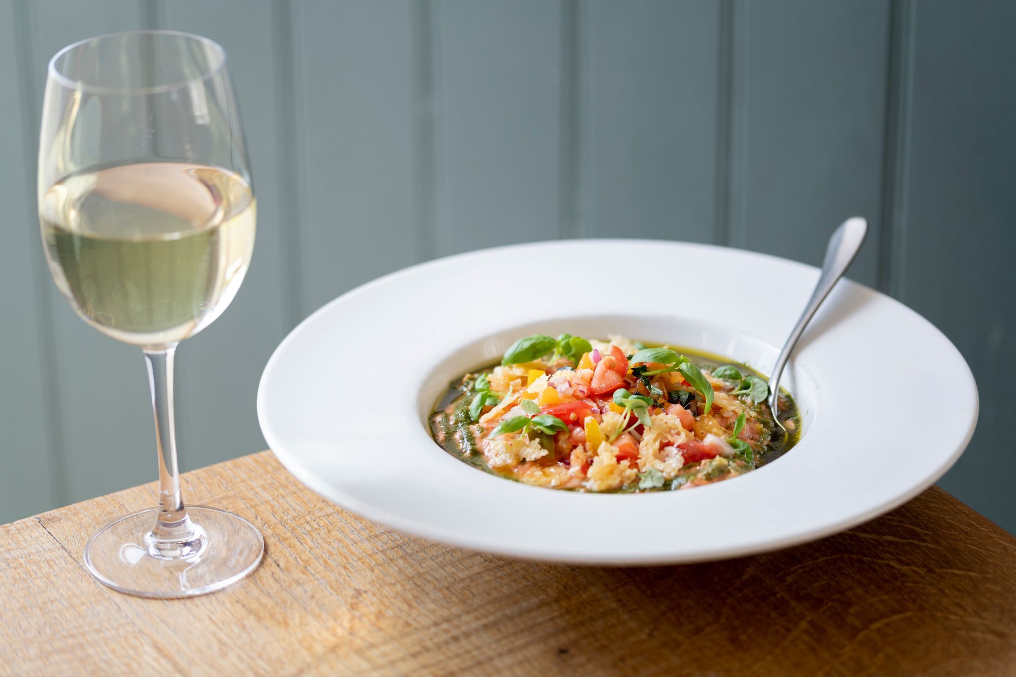 rice dish served in white plate and with the glass of white wine