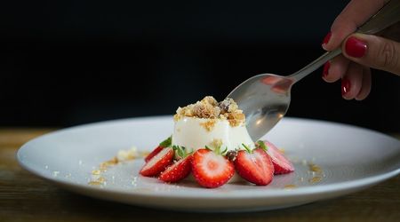 Panna cotta dessert with fresh strawberries and a crumble