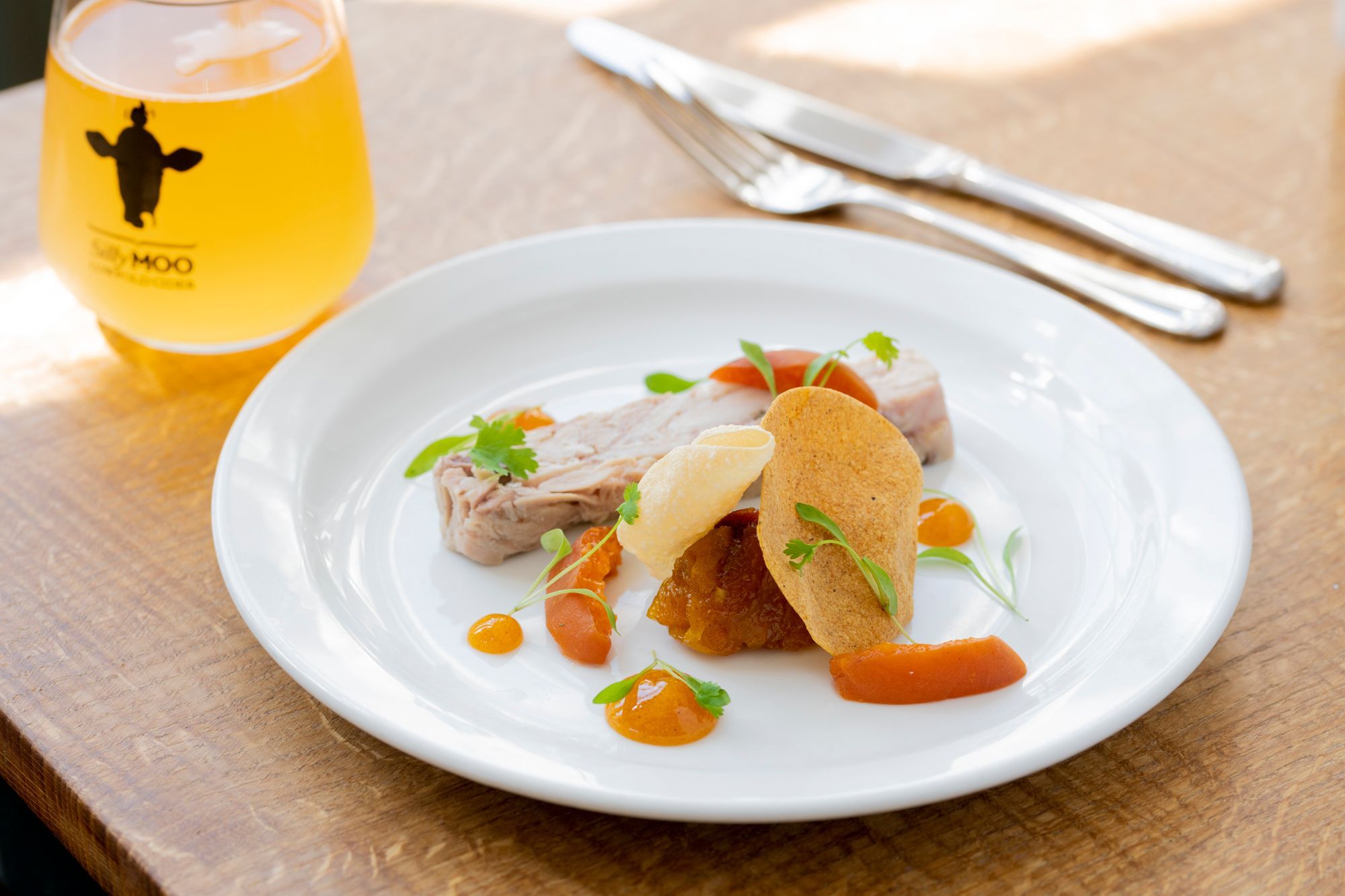 dish served on the white plate and with glass of cider