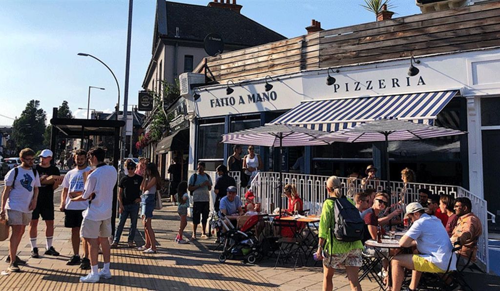 A busy Fatto A Mano in Preston Circus. Located on London Road in Brighton close to Brighton's Preston park. a summery picture with blue sky. Fatto a Mano Preston Circus • Artisan Pizza with a Community Feel