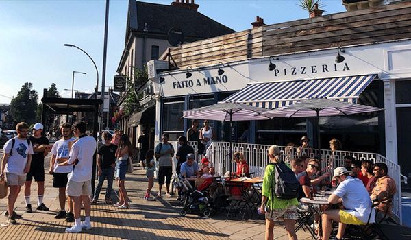 A busy Fatto A Mano in Preston Circus. Located on London Road in Brighton close to Brighton's Preston park. a summery picture with blue sky. Fatto a Mano Preston Circus • Artisan Pizza with a Community Feel