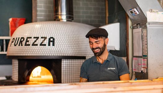 pizza chef smiling while making pizza