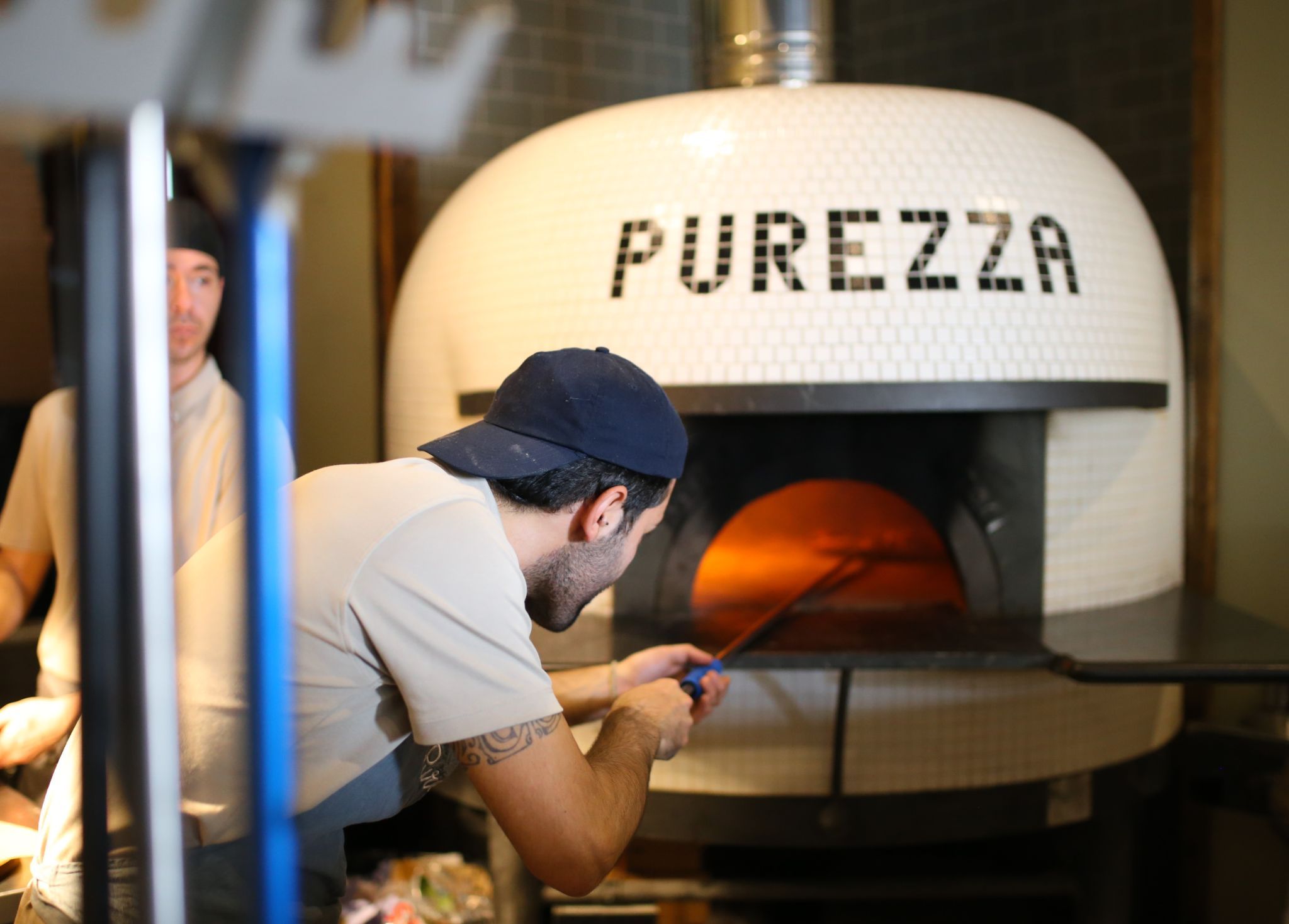chef placing pizza in the brick oven