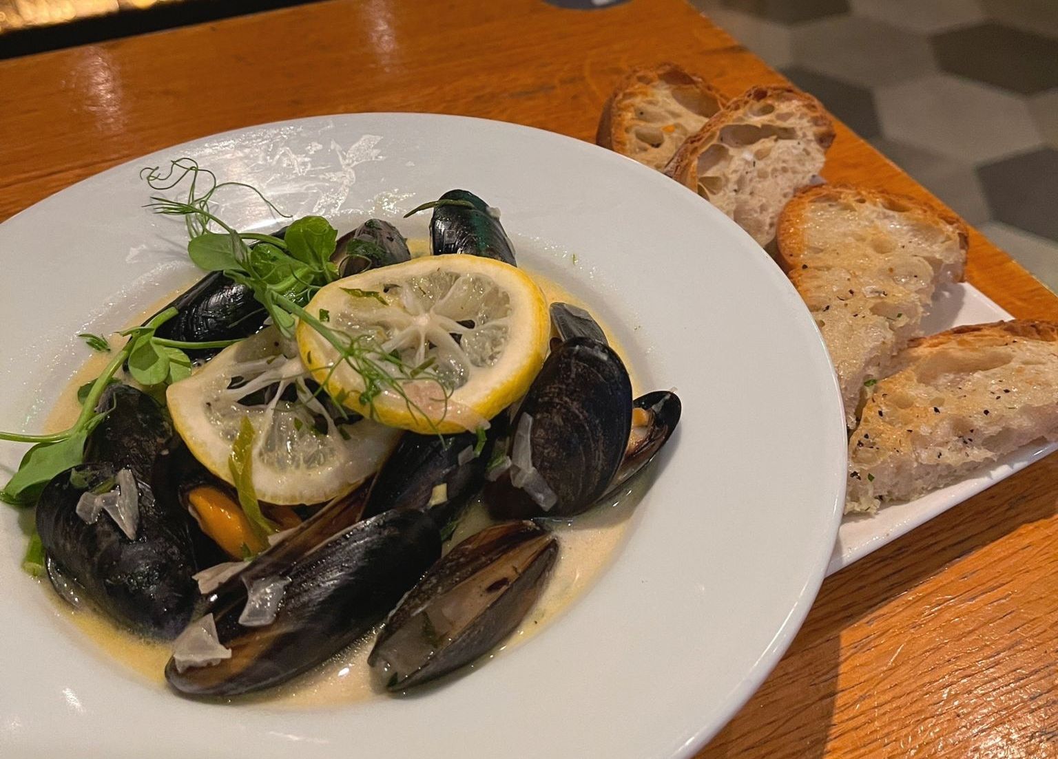 white plate with the mussels and lemon