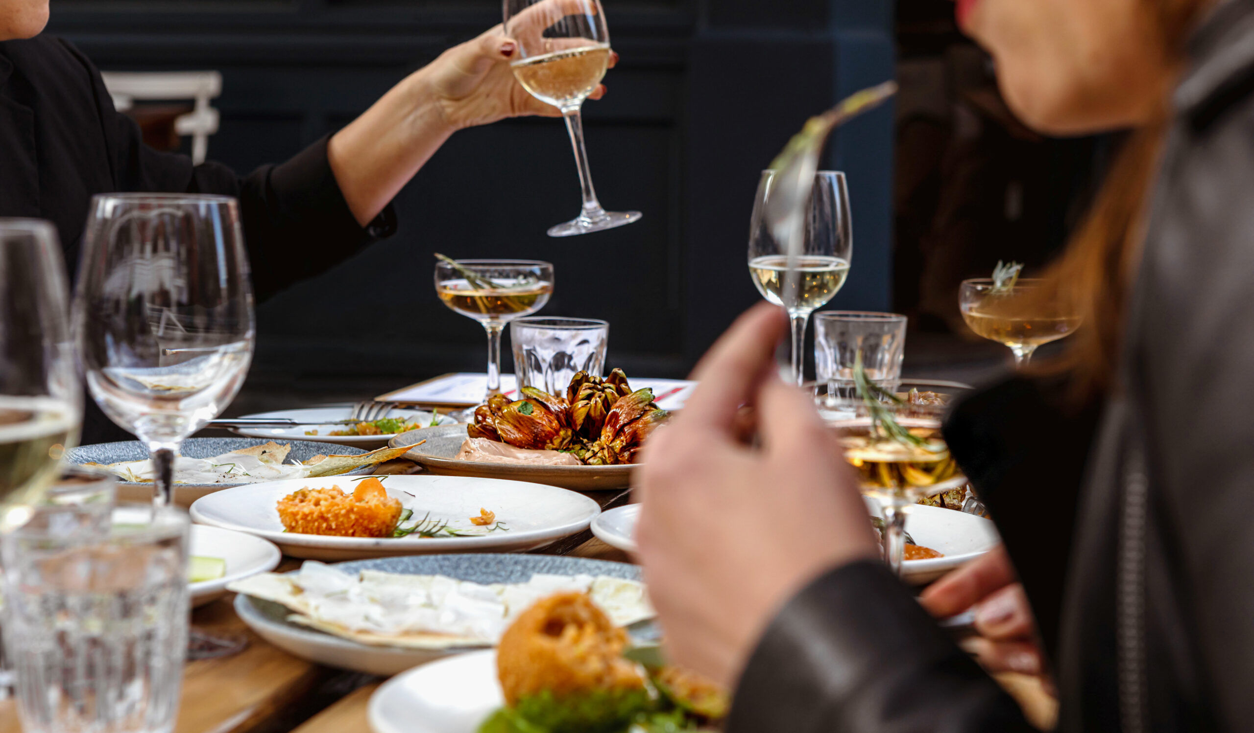 People eating food and drinking glasses of wine at Italian restaurant in Hove, Cin Cin.