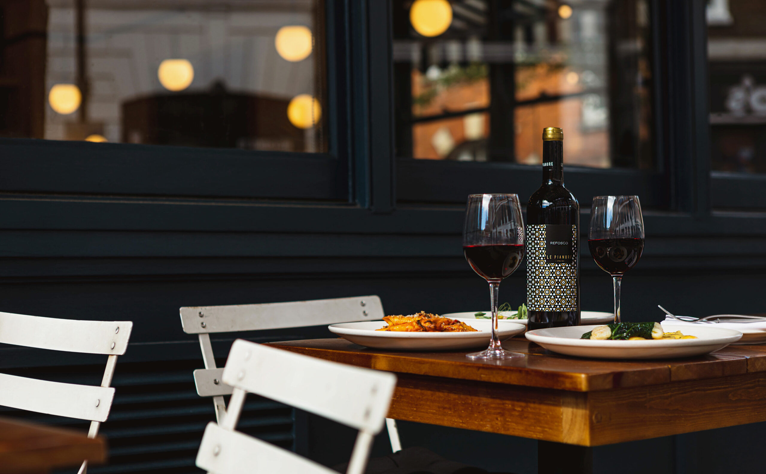 A table with food and wine in the courtyard at Cin Cin. 