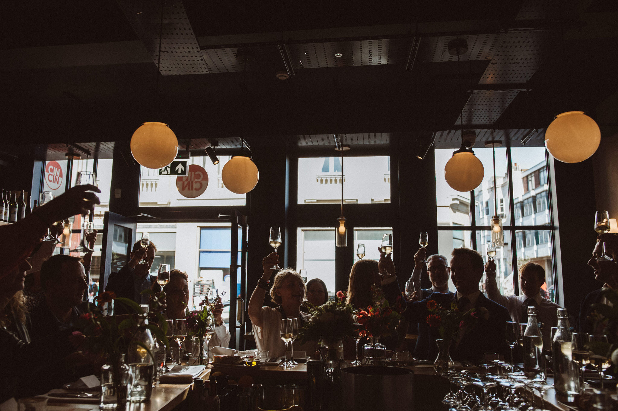 A wedding at Cin Cin restaurant with everyone toasting their glasses of champagne.