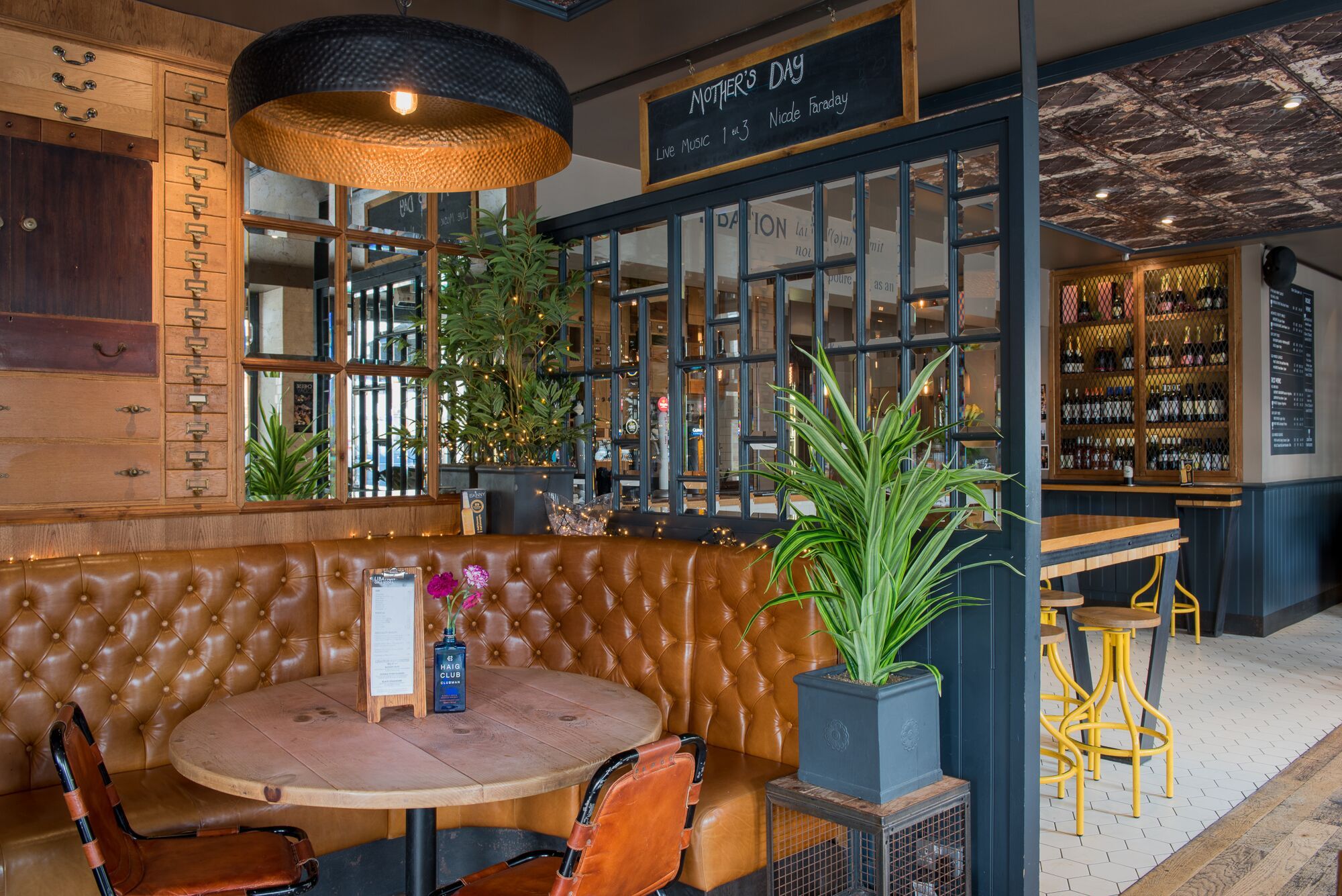 Modern interior with plants and large ceiling lights. brunch at Libation bar 