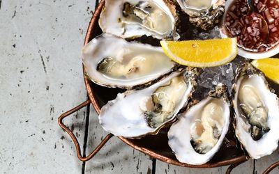 A platter of large oysters with fresh lemon and shallot vinegar