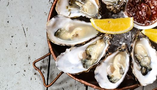 A platter of large oysters with fresh lemon and shallot vinegar