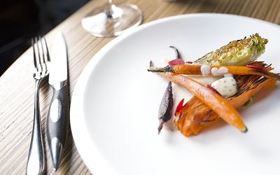 A minimalist plate of carrots, beetroot and charred gem lettuce served on a porcelain plate