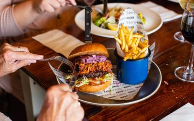 cutting piece of delicious looking burger at Ladies Mile Pub