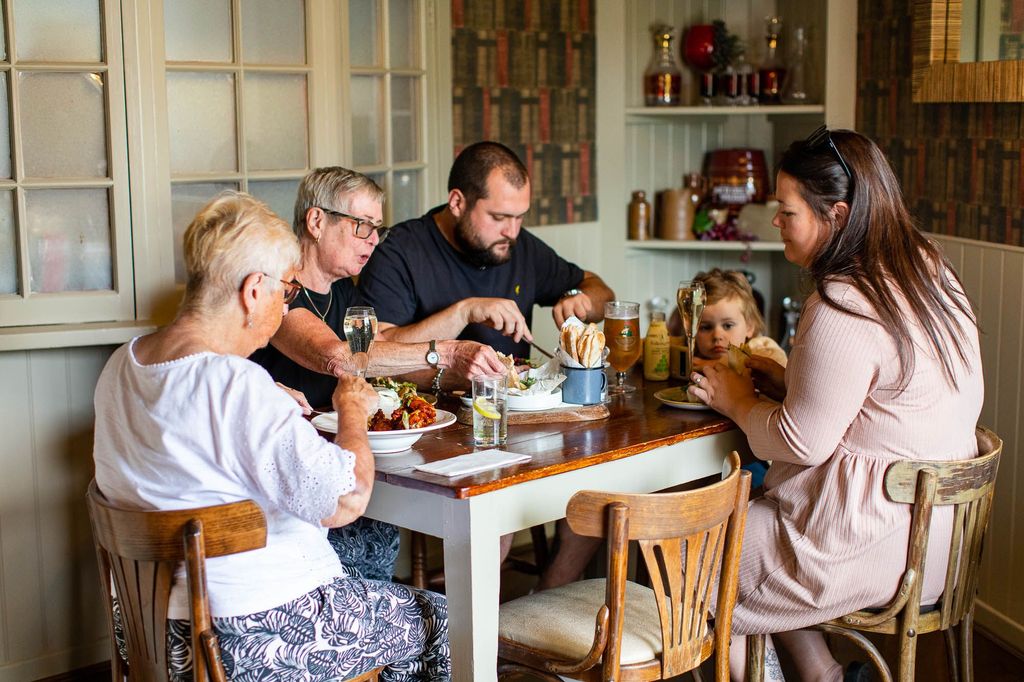 family of five sitting by the table and enjoying their food