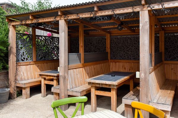 covered garden area of ladies mile pub, wooden bench and tables