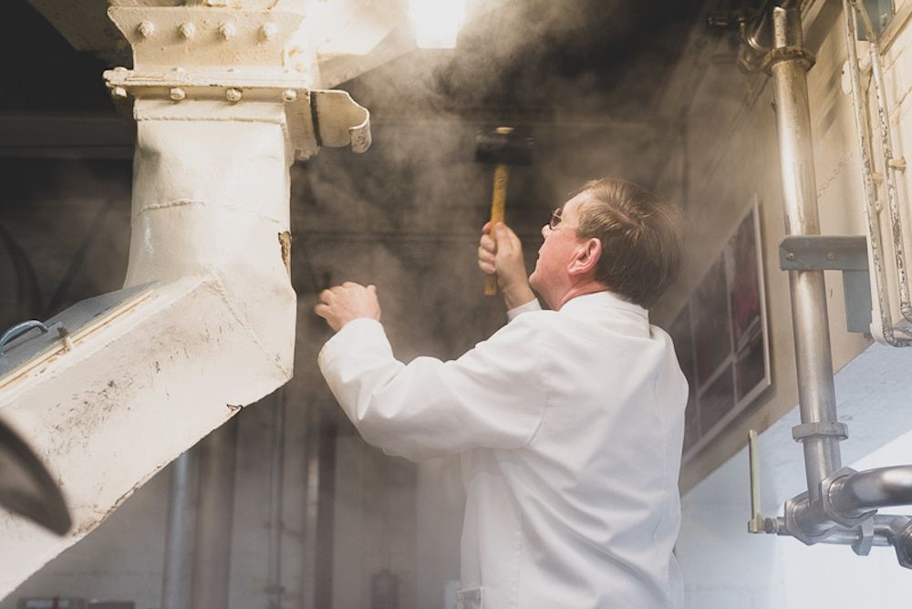 Man banging a hammer in the brewery